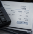 Calculator resting on construction invoices with one invoice showing a zero VAT total under reverse charge VAT rules